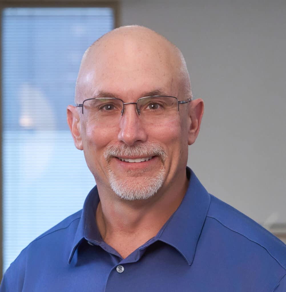 A profile image of Adam Hoyles, in glasses and a blue dress shirt. The wetland expert leads our environmental team in Florida.